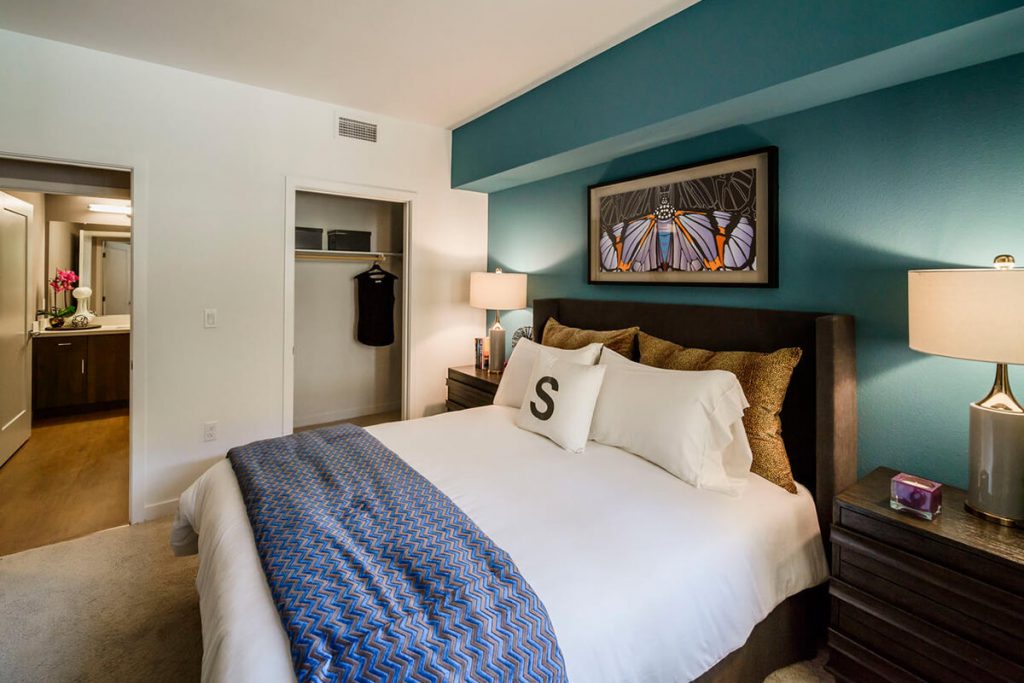 One-BR Apartments in Sunnyvale, CA - 6TenEAST - Bedroom with Plush Carpet Flooring, Bed, Nightstands with Lamps, and Spacious Closet