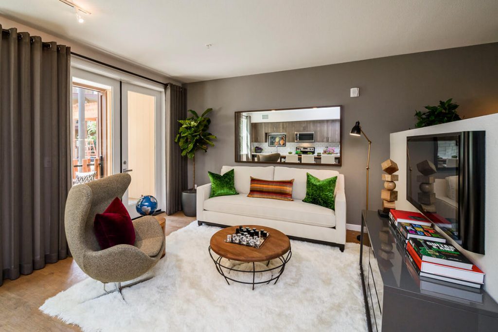 Pet-Friendly Apartments in Sunnyvale, CA - 6TenEAST - Living Room with Decorative Decor, Large Window, and Glass-Paneled Door with Access to Balcony